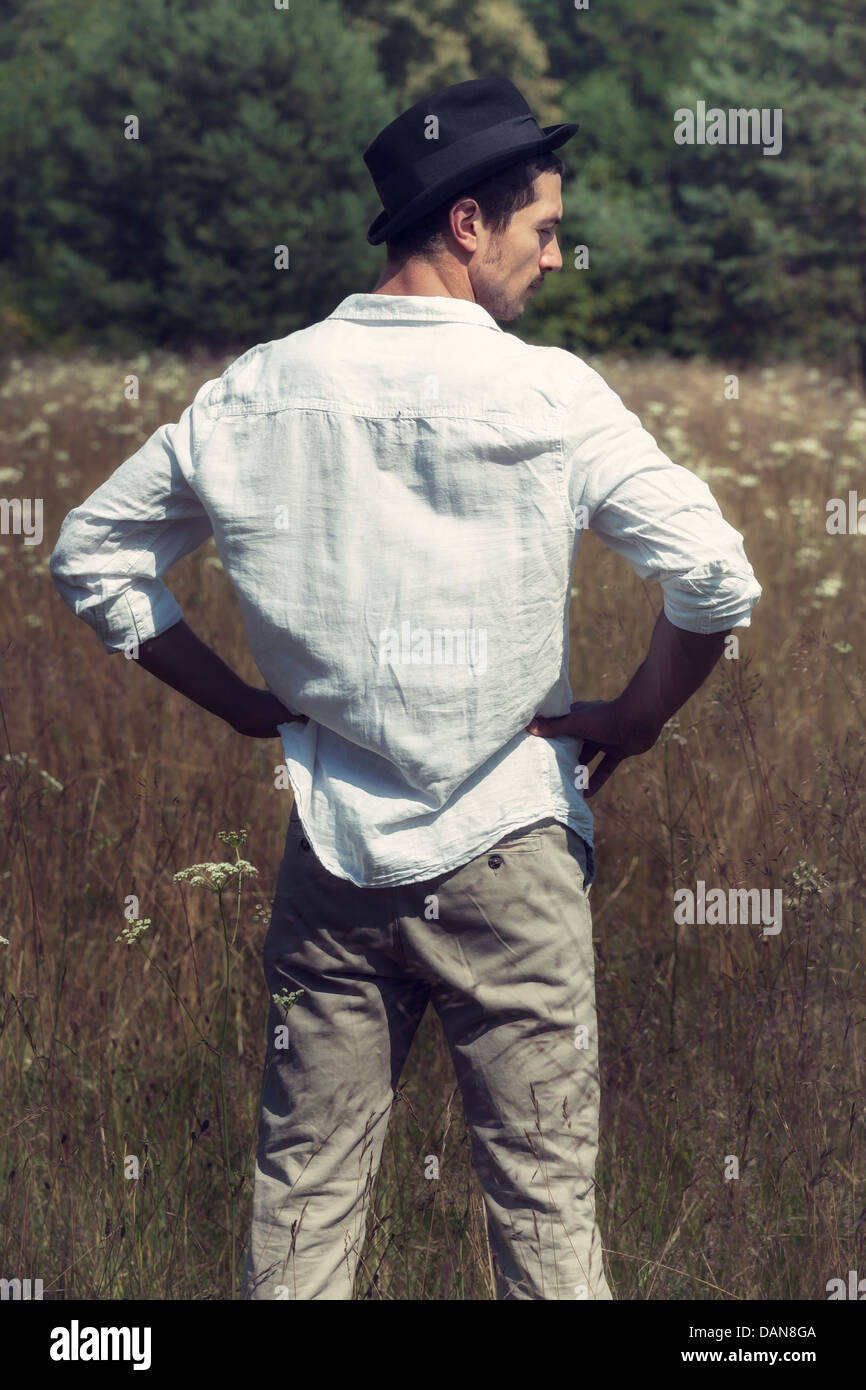 a man with a black hat standing on a field Stock Photo