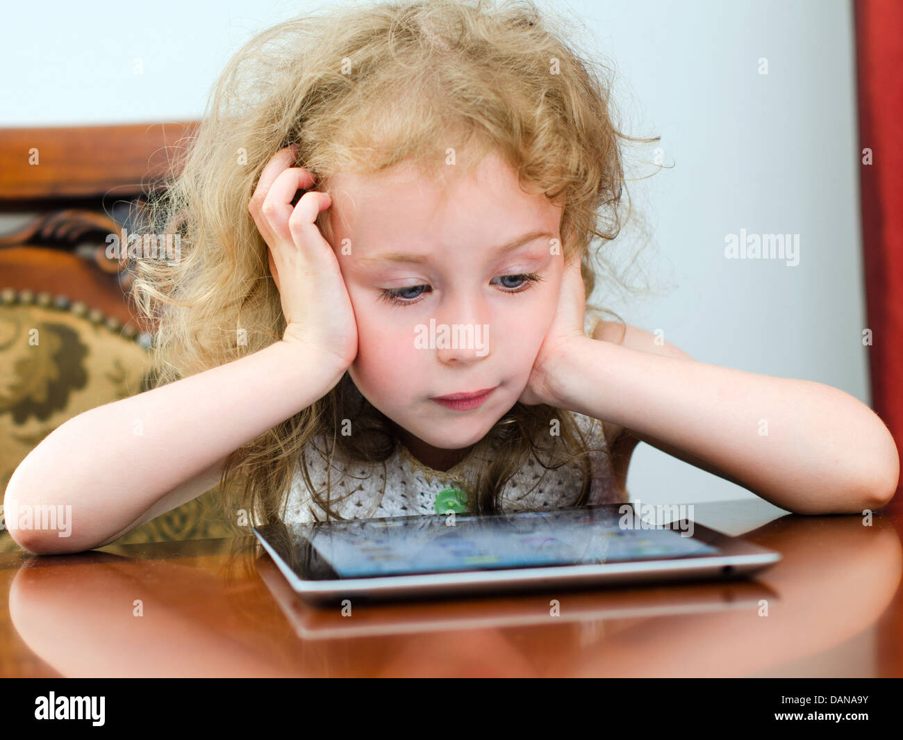 Cute little girl using tablet pc Stock Photo - Alamy