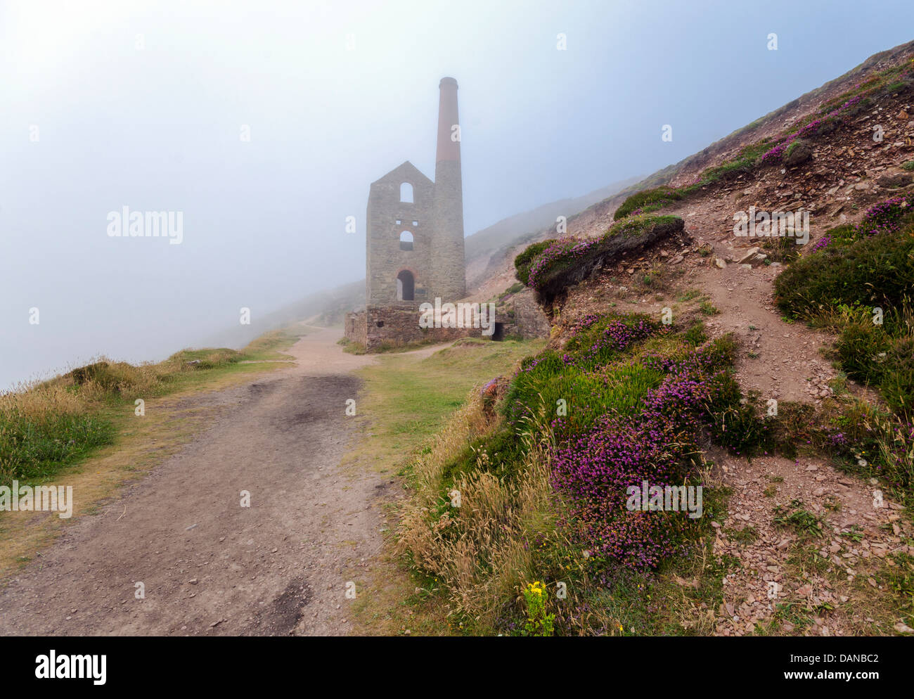 The ruins of Towanroath pumping engine house rising out of the mist at Wheal Coates at St. Agnes in Cornwall Stock Photo