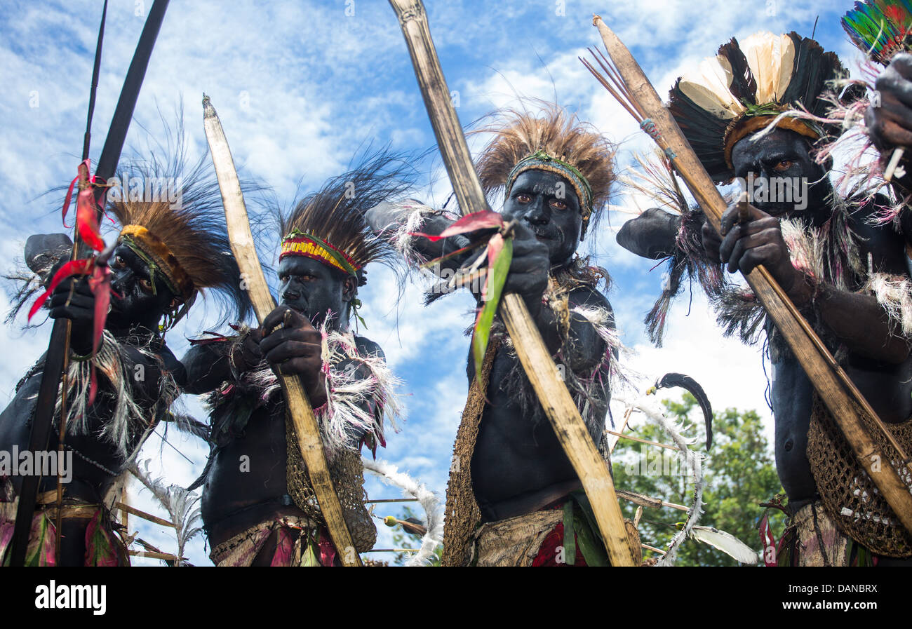 Looking up at a group of tribal warriors with drawn bow and arrows