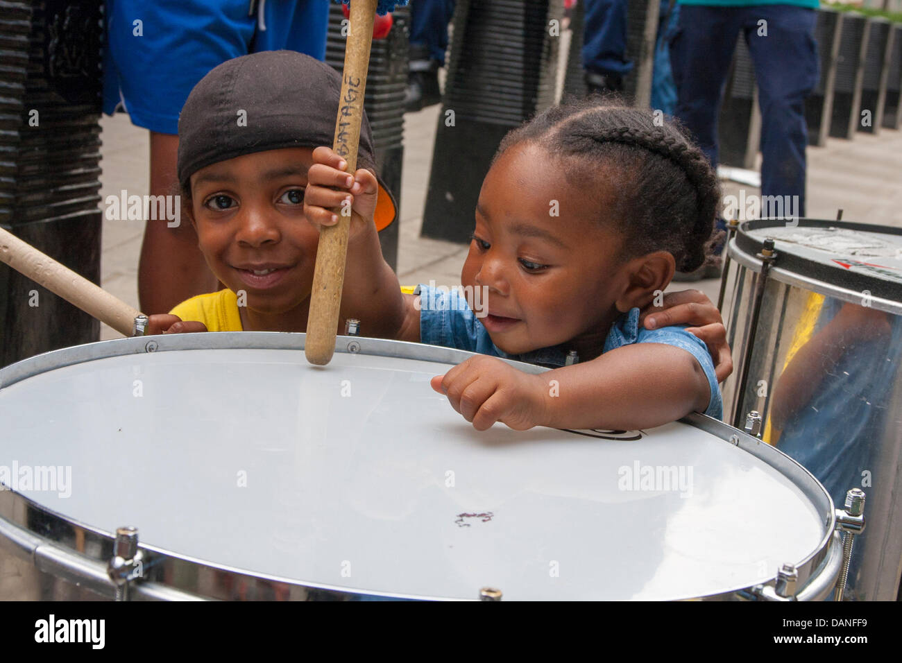 London, UK. 16th July, 2013. Two little children play with a drum as protesters demonstrate outside the US embassy in London against the acquittal of George Zimmerman who shot 17 year-old Trayvon Martin in Florida. Credit:  Paul Davey/Alamy Live News Stock Photo