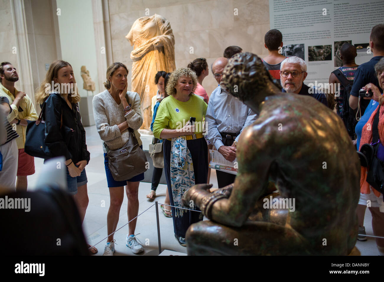 Viewers at The Metropolitan Museum of Art observe 'The Boxer At Rest,' a bronze sculpture from the 4th-2nd century B.C. Stock Photo