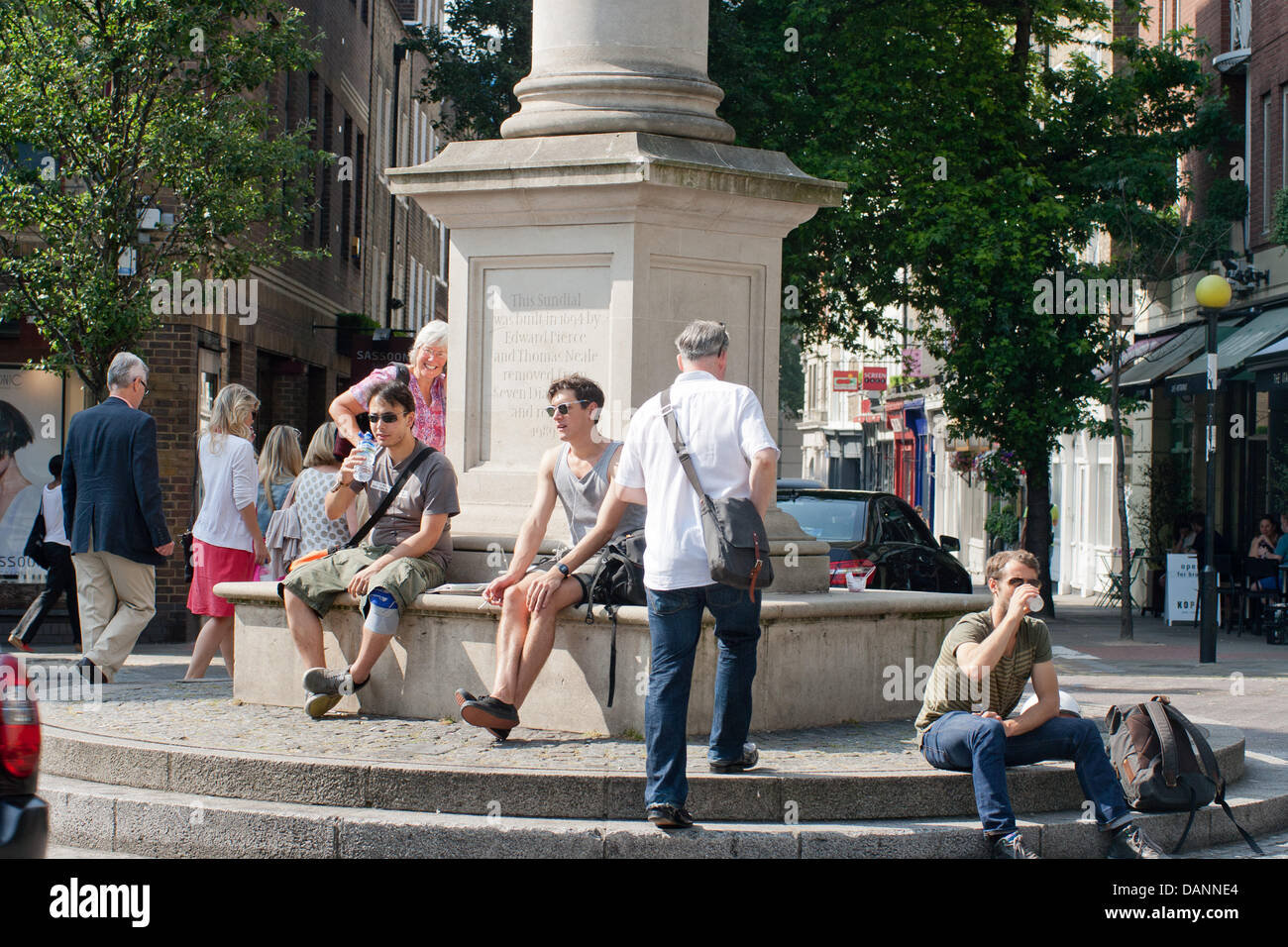 London, UK. 13/07/2013. Londoners enjoying the hot weather, at Seven Dials Monument in Covent Garden . Peter Barbe / Alamy Stock Photo