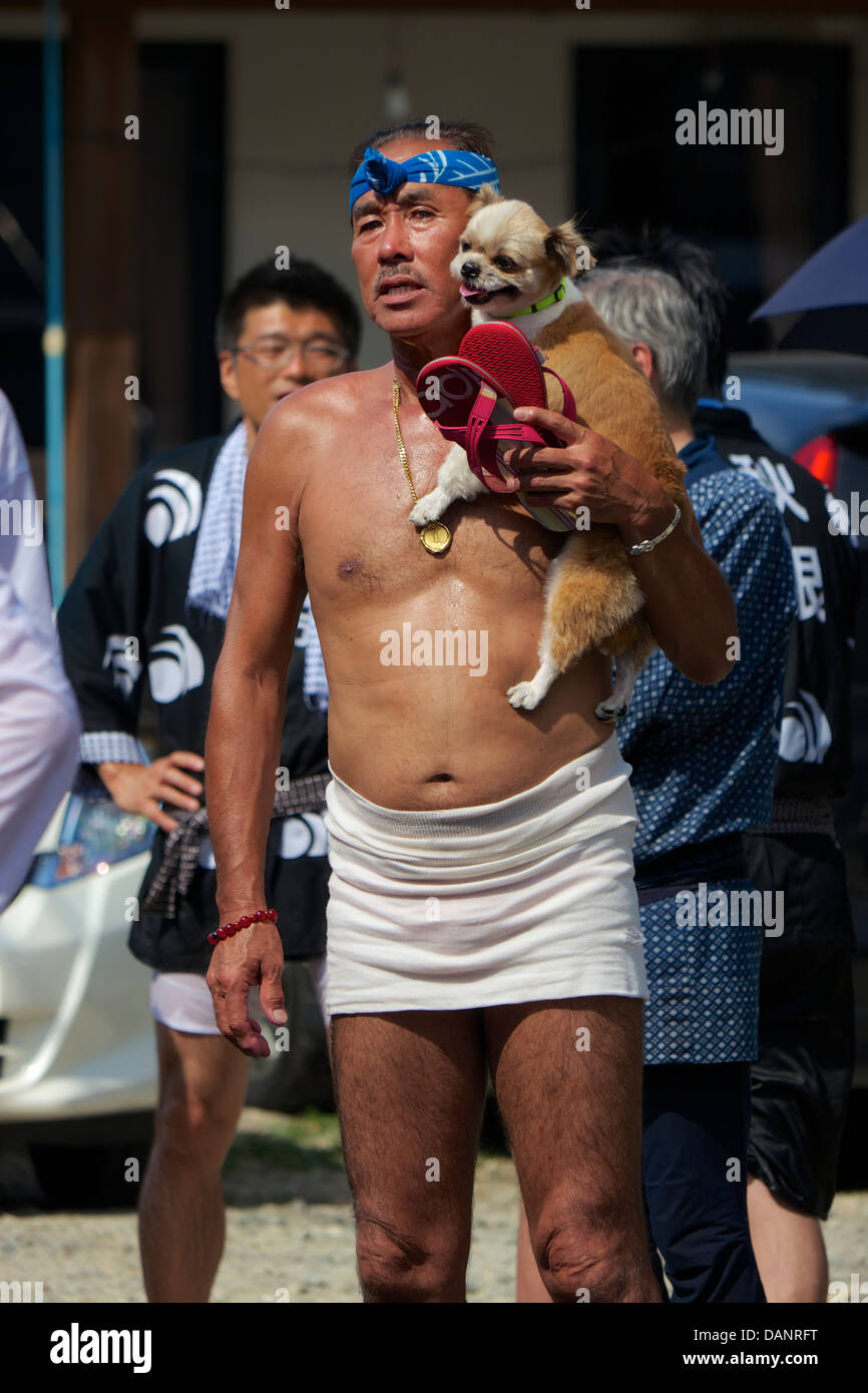 Shirtless Japanese Man wrapped in traditional loincloth (fundoshi) at the  waist carrying his pet dog at a local festival, Akita Stock Photo - Alamy