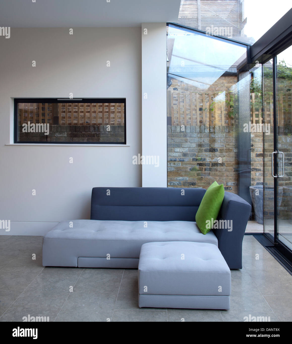Dents Road, London, United Kingdom. Architect: h2 Architecture, 2012. L-shaped sofa in glazed conversion. Stock Photo