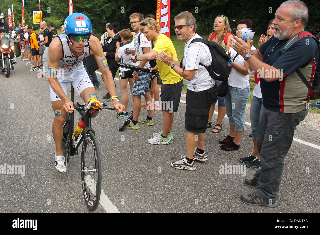 German triathlete Andreas Raelert gets on his bike after the swimming etappe during the 10th Ironman Challenge in Roth, Germany, 10 July 2011. For the ironman, the participants have to swim 3,8 km, cycle 180 km and run 42,195 km. Photo: Daniel Karmann Stock Photo