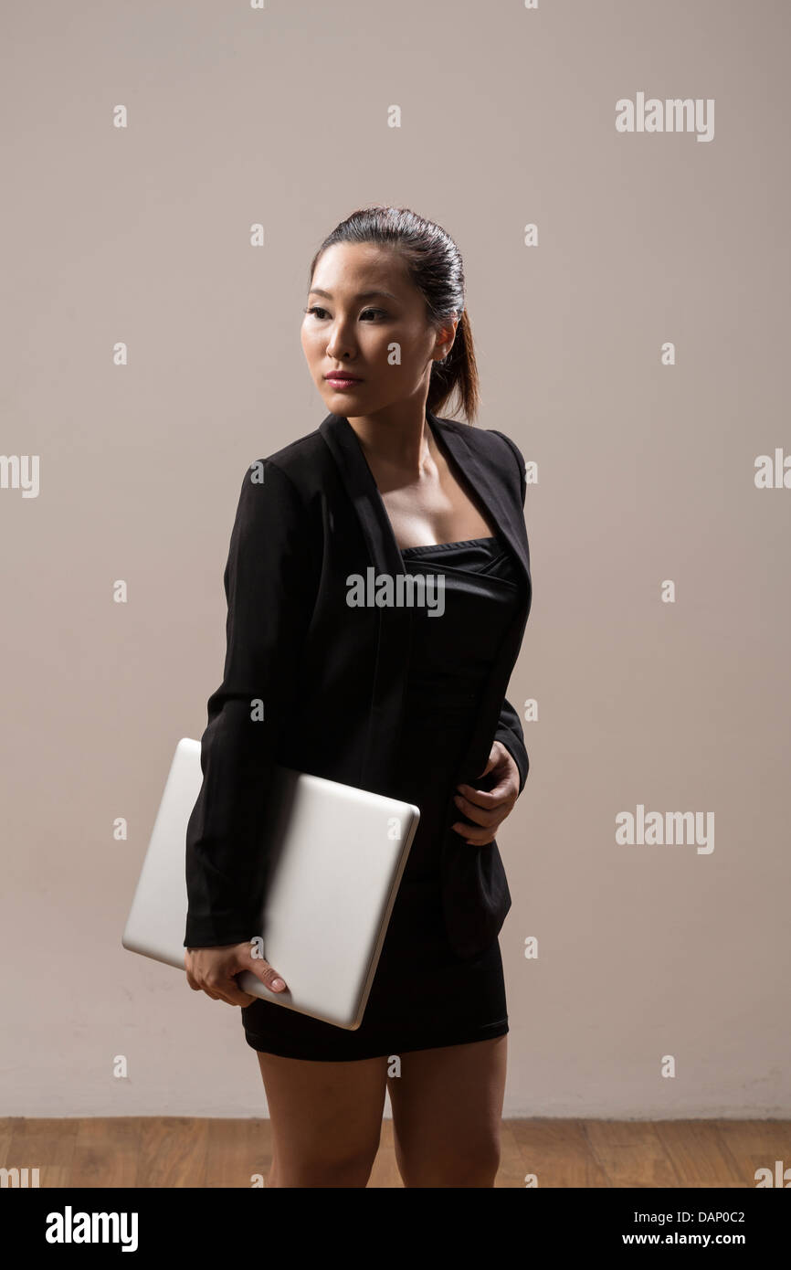 Portrait of a Stylish Chinese Business woman Carrying a Laptop Stock Photo