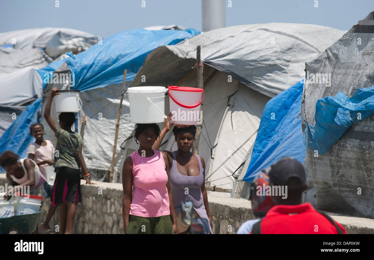 Haitians walk past emergency shelters on a street in PortauPrince, Haiti, 17 July 2011. German