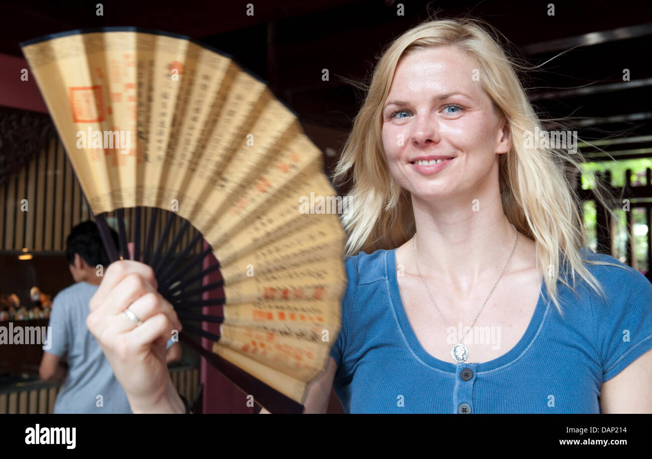 The picture made available 20 July 2011 shows German swimmer Britta Steffen flattering a fan during a visit of the Cheng Huang Miao Temple in the Yu Garden prior to the 2011 FINA World Swimming Championships in Shanghai, China, 18 July 2011. Photo: Bernd Thissen dpa Stock Photo