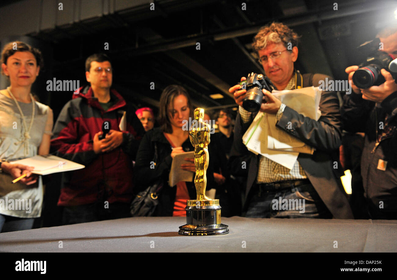 Journalists observe the Oscar that was given to Maximilian Schell in 1962 for his part in the movie 'Judgment at Nuremberg' at the German Film Museum in Frankfurt Main, Germany, 20 July 2011. After 20 months of reconstructing the building of the German Film Museum the venue is open to the public again on 14 August 2011. Photo: Marc Tirl Stock Photo
