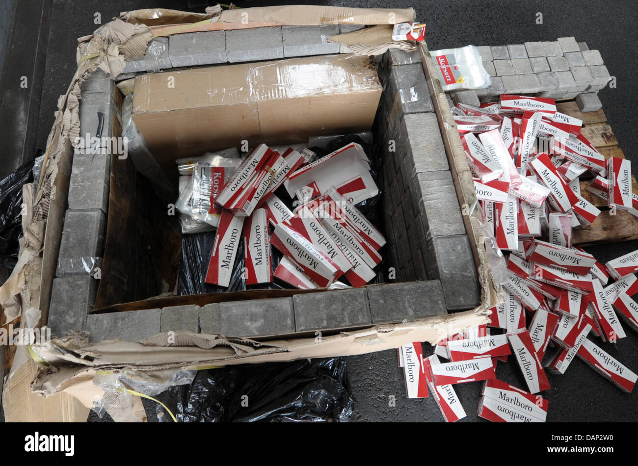 A load of fake Marlboro cigarettes is surrounded by paving stones at a warehouse in Hamburg, Germany, 21 July 2011. The customs investigation office seizured 13 million cigerettes. Christian Charisius Stock Photo