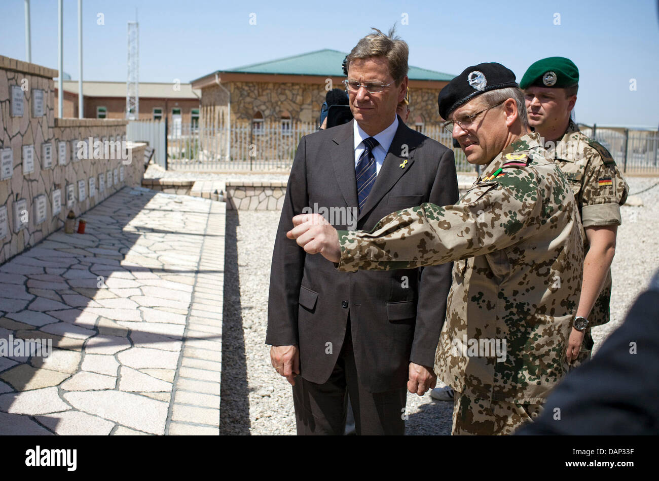 German Foreign Minister Guido Westerwelle (L-R), Brigadier General Dirk Backen, deputy head of the German contingent at the regional squad North and Major Andre Wuestner, deputy federal chairman of the German Armed Forces Association, commemorate soldiers killed in action at a grove of honor in Mazar-i-Sharif, Afghanistan, 22 July 2011. Westerwelle started his fourth trip of the ye Stock Photo
