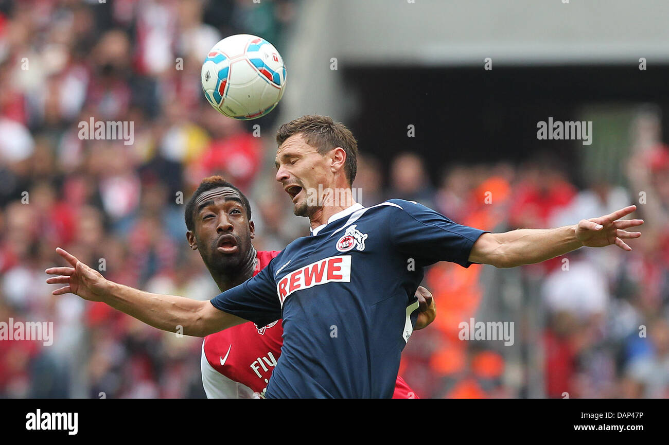 London's Johan Djourou (BACK) and Cologne's Milivoje Novakovic (FRONT) vie for the ball during the soccer test match 1st FC Cologne vs Arsenal London at Rhein-Energie Stadium in Cologne, Germany, 23 July 2011. Photo: Fabian Stratenschulte Stock Photo