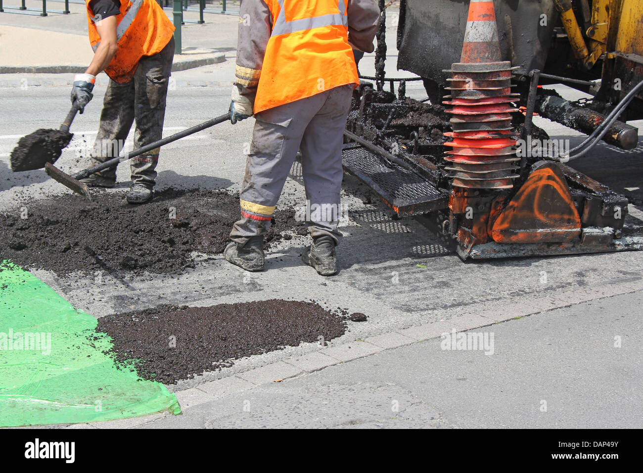 Workers on Asphalting paver machine during Road street repairing works Stock Photo