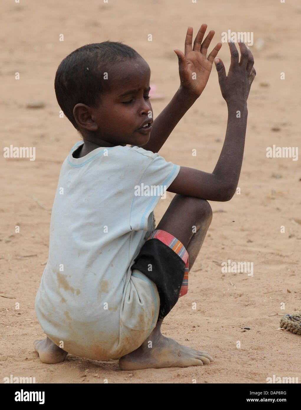 A little somalian raising his hands in a refugee camp in Dadaab, northeastern Kenya on Tuesday, August 2nd 2011. Somalia and parts of Kenya have been struck by one of the worst droughts and famines in six decades, more than 350.000 refugees have found shelter in the worlds biggest refugee camp. Foto: Boris Roessler dpa  +++(c) dpa - Bildfunk+++ Stock Photo