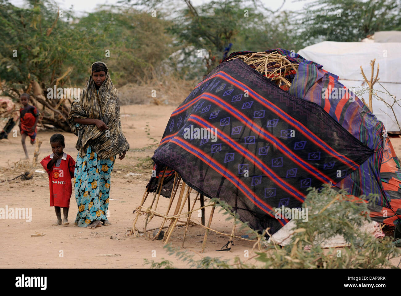 Somalian refugees walk past their tents in a refugee camp in Dadaab, northeastern Kenya on Tuesday, August 2nd 2011. Somalia and parts of Kenya have been struck by one of the worst droughts and famines in six decades, more than 350.000 refugees have found shelter in the worlds biggest refugee camp. Foto: Boris Roessler dpa  +++(c) dpa - Bildfunk+++ Stock Photo