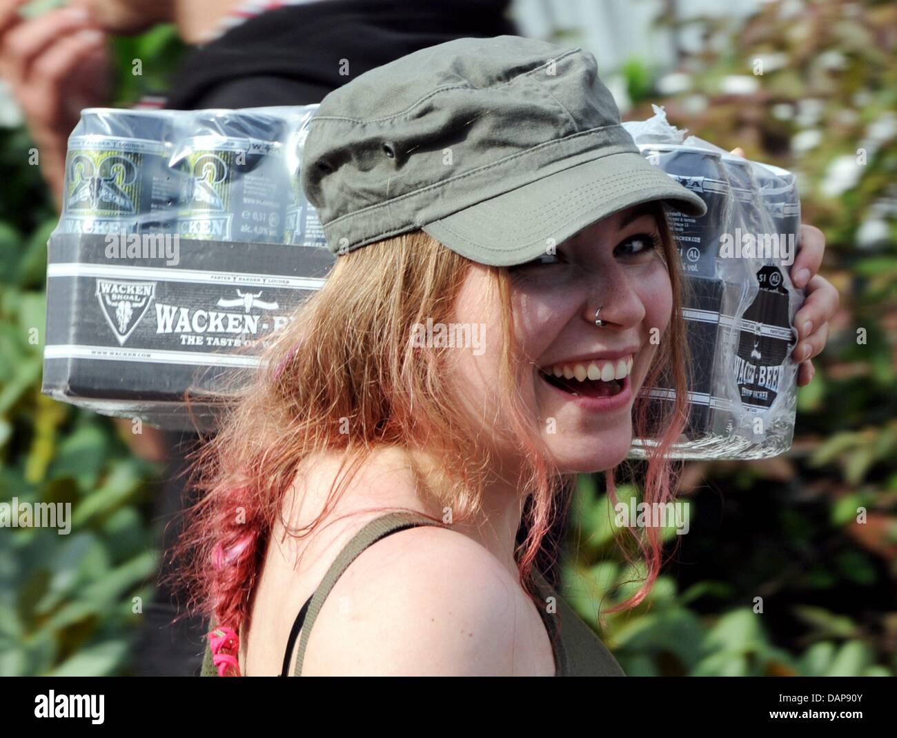 A female heavy metal fan carries beer to the camping site in Wacken