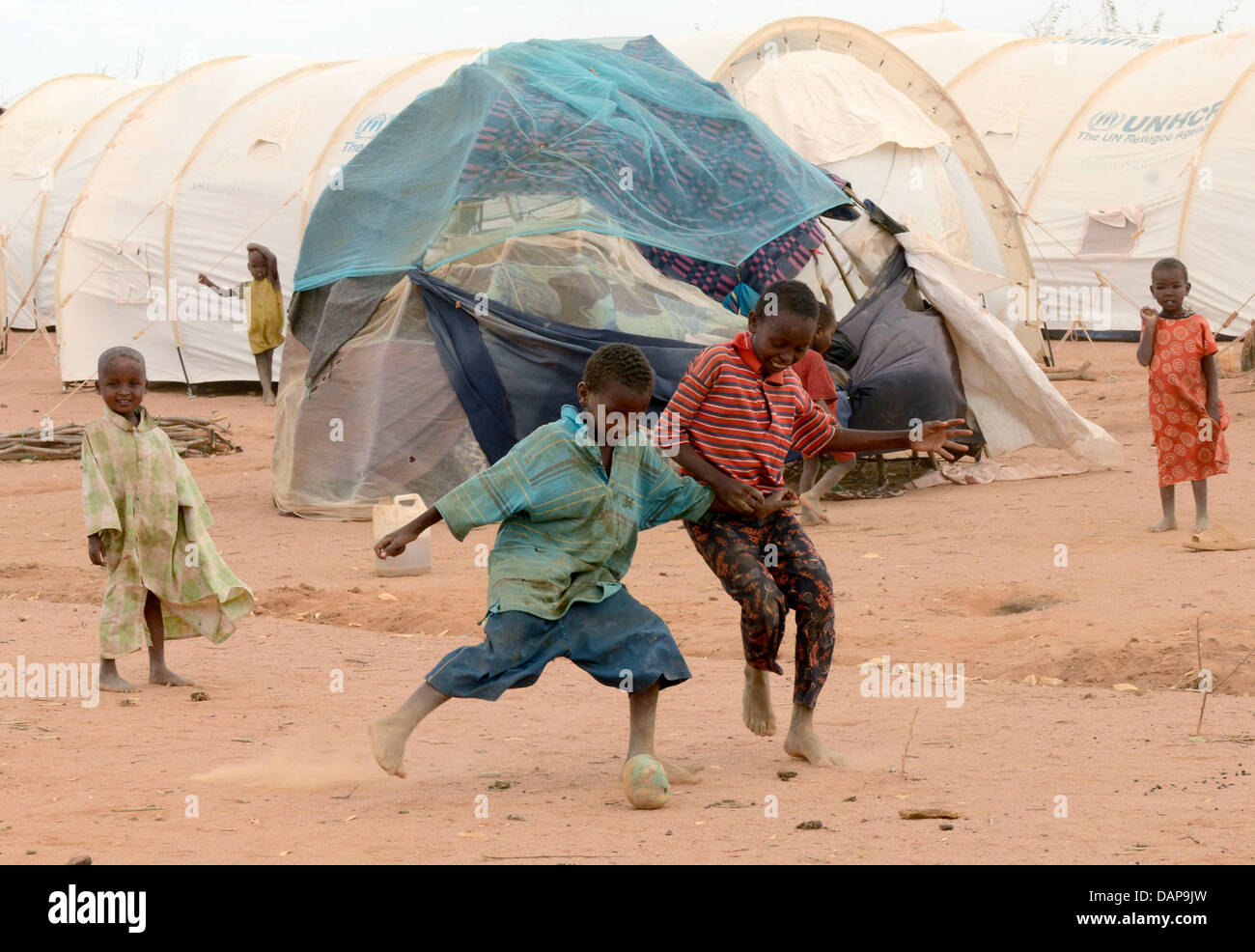 Boys play soccer at a refugee camp in Dadaab, Kenya 4 August 2011. Somalia and parts of Kenya have been struck by one of the worst draughts and famines in six decades, more than 350 000 refugees have found shelter in the worlds biggest refugee camp. Photo: Boris Roessler Stock Photo