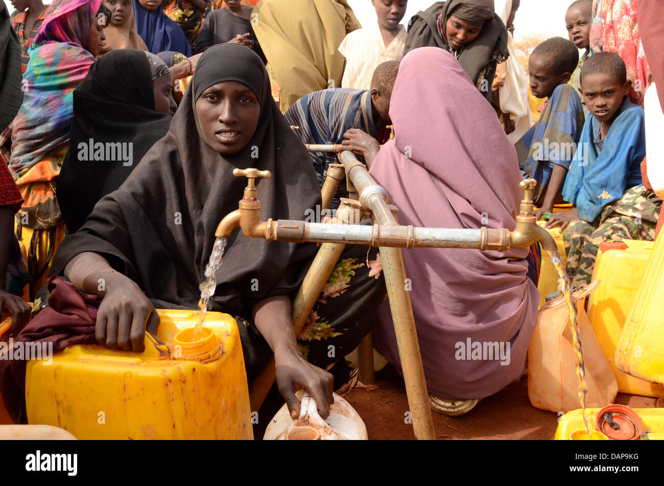 Women fill canisters with drinking water at a refugee camp in Dadaab