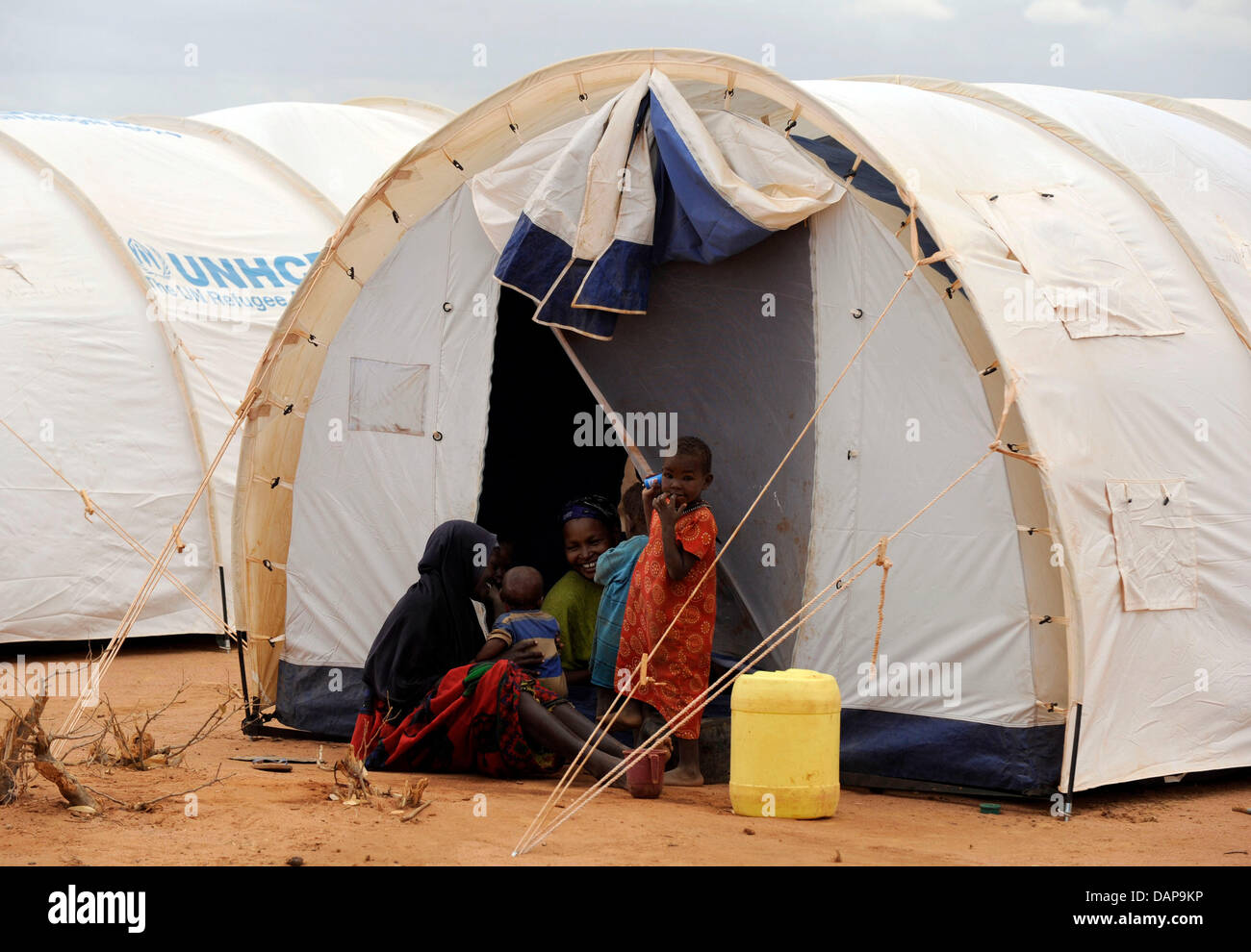 Refugees sit outside their tent at a refugee camp in Dadaab, Kenya 4 August 2011. Somalia and parts of Kenya have been struck by one of the worst draughts and famines in six decades, more than 350 000 refugees have found shelter in the worlds biggest refugee camp. Photo: Boris Roessler Stock Photo