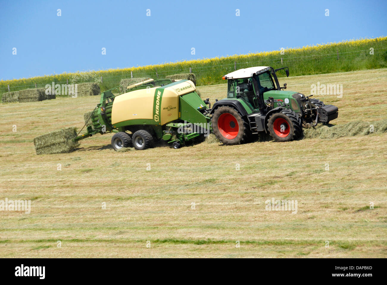 Tractor with baler making hay bales for silage, Sussex, England UK