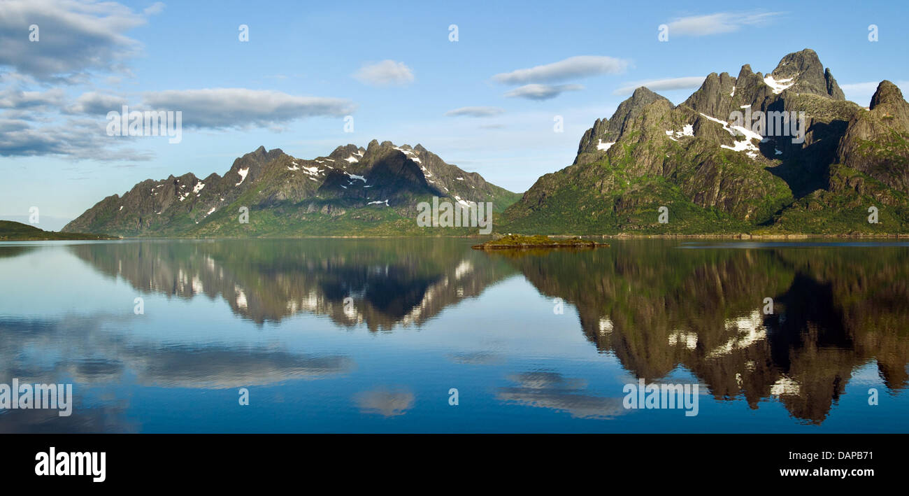 Mountains are reflected in the water on the Raftsund shores on the islands of Lofoten in Digermulen, Norway, 25 July 2011. The 190 km long island chain Lofoten features spectacular sites and mountains. Situated 100 to 200 km north of the Polar circle in the Norwegian Sea, the islands share the 67th/68th degree of latitude with central Greenland and North Alaska. About 20 per cent o Stock Photo