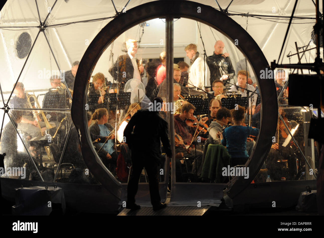 The orchestra performs in a transparent tent during the opera 'Magic Flute' by Wolfgang Amadeus Mozart at the sea festival Berlin at the sea stage of the lido Wannsee in Berlin, Germany, 09 August 2011. The opera will be staged from 11 to 28 August 2011. Photo: Jens Kalaene Stock Photo