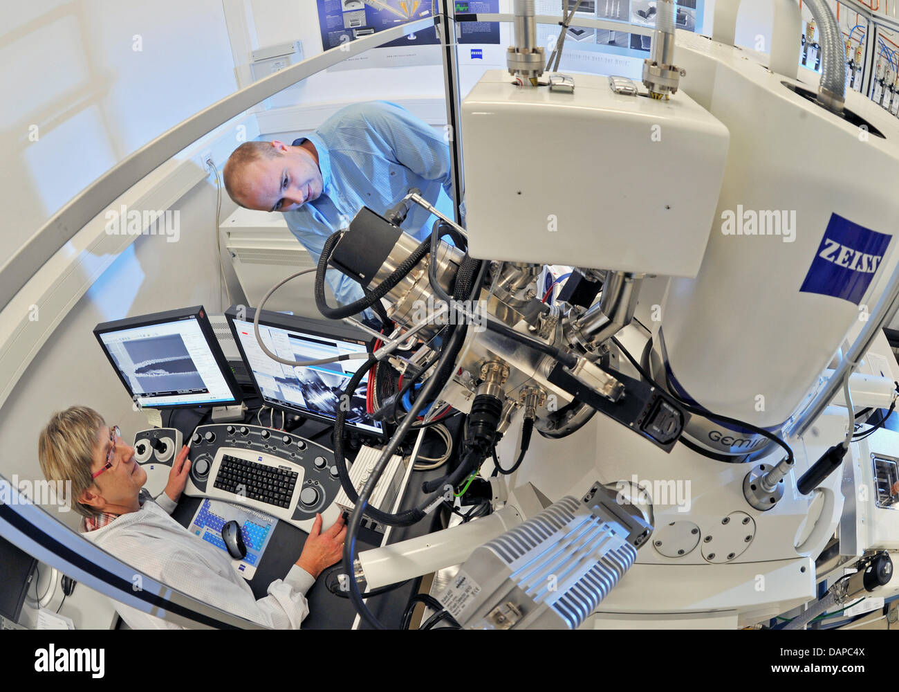 Graduate engineers Iris Hoebelt and Sven Haas prepare for an experiment with a CrossBeam System at a laboratory of the Fraunhofer-Institute for Electronic Nano Systems (ENAS) in Chemnitz, Germany, 10 August 2011. The institute researches and developes in the field of Smart Systems Integration with the help of micro and nano technology. As part of the 'Two Days of Industry Culture', Stock Photo