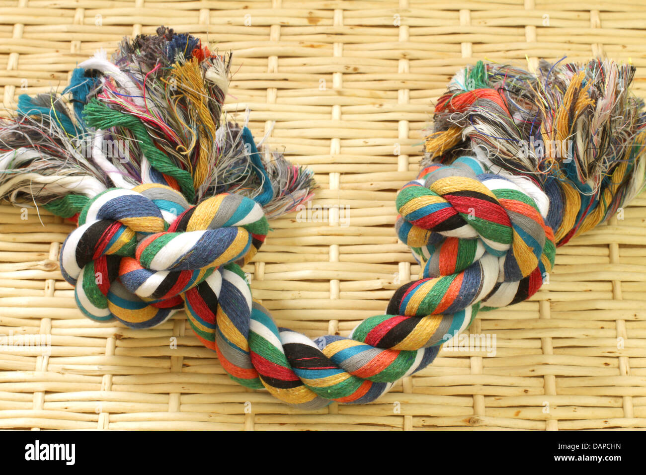 Coloured rope with two knots on bamboo platemate Stock Photo