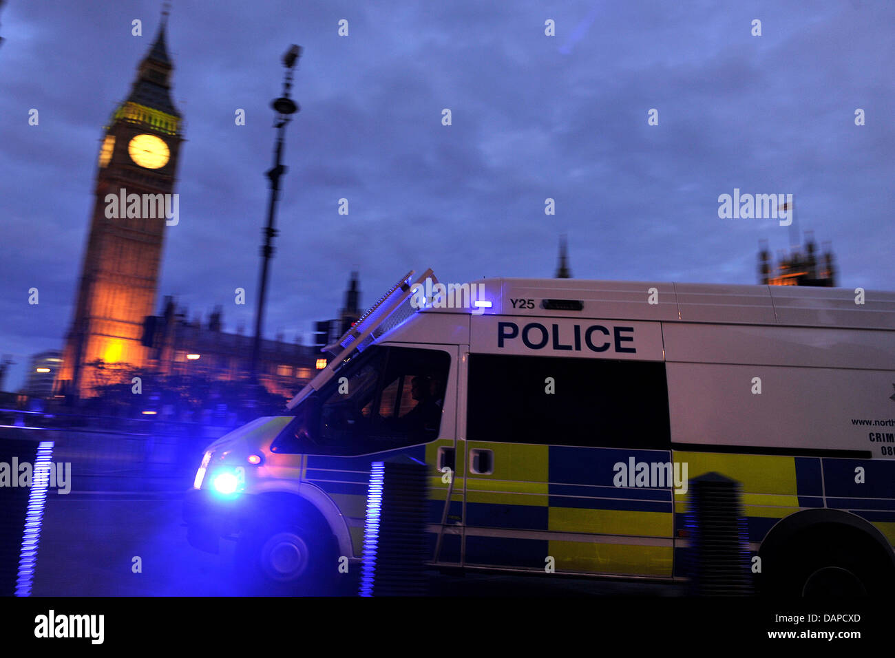 A police van rushes through the street in front of the Houses of ...
