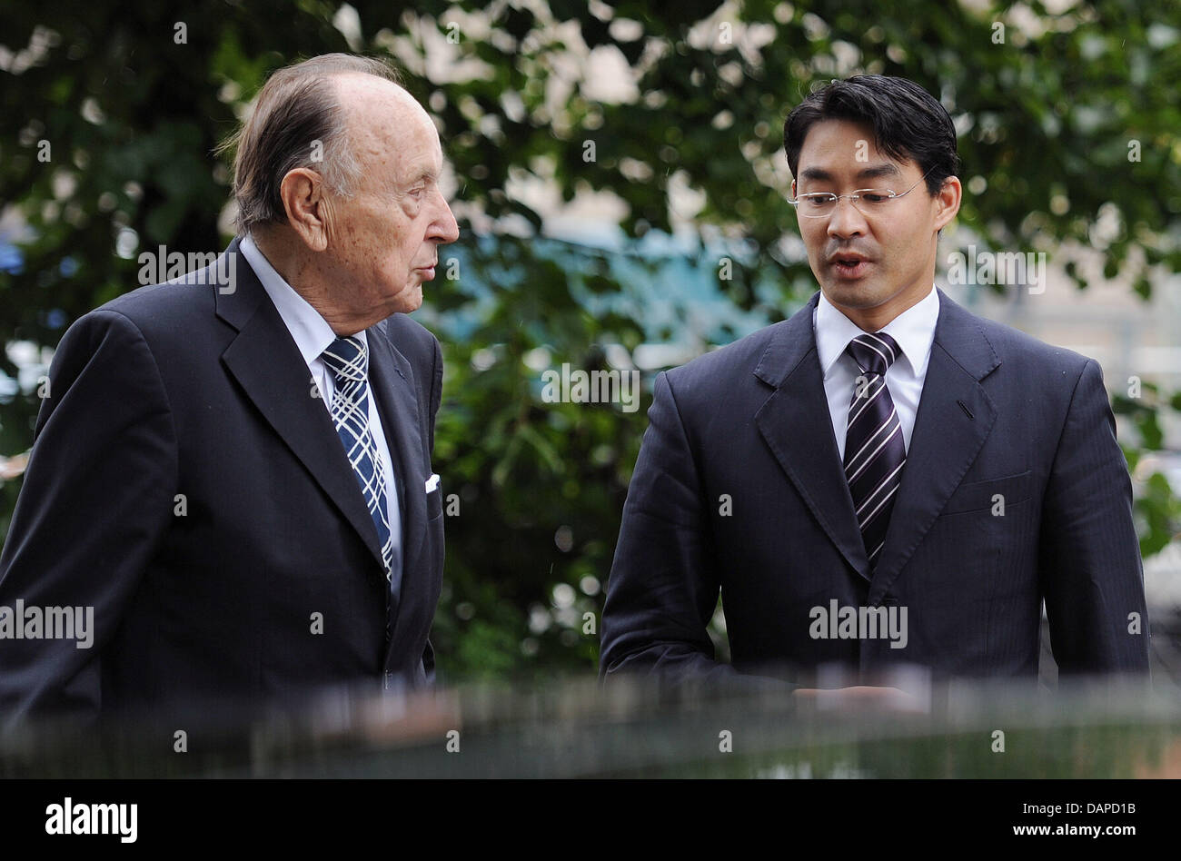 The former foreign minister and today's honorary FDP chair Hans-Dietrich Genscher (R) and FDP chairman and Economy Minister Philipp Roesler talk after having laid down a wreath at the Sandkrug bridge in Berlin, Germany, 12 August 2011. They remembered the victims of the Berlin Wall earlier, which was constructed 50 years ago on 13 August 1961. Photo: HANNIBAL Stock Photo