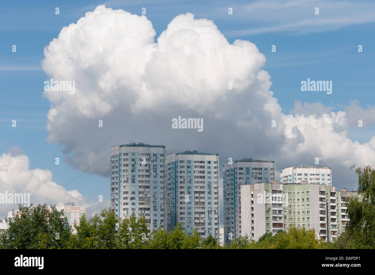 Blocks of flats under big white cloud at summer Stock Photo