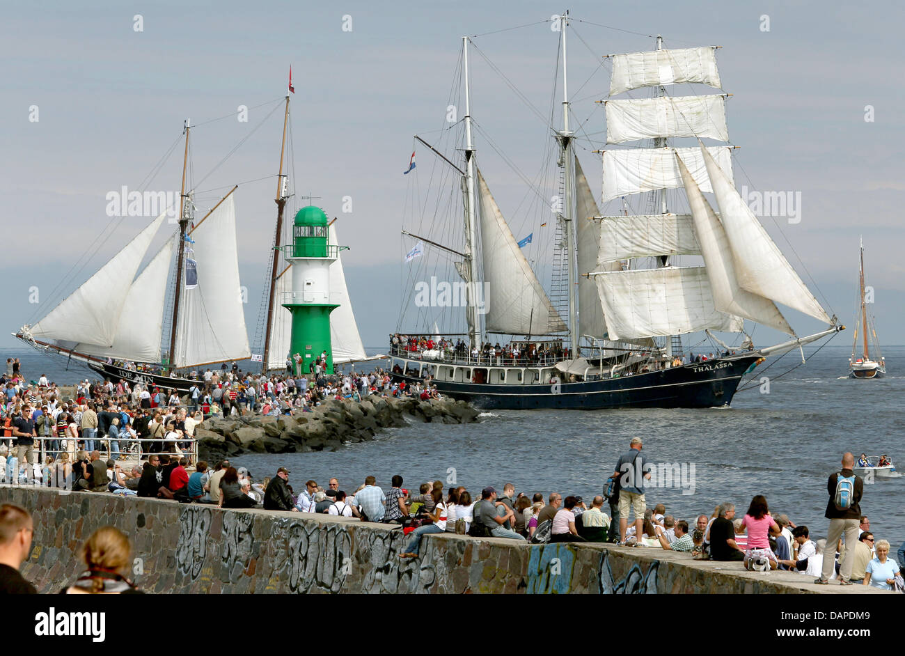 Onlookers watch the fleet sail on the Baltic Sea at the 21st Hanse Sail from the Warnemuend Mole in Rockstock, Germany, 13 August 2011. Around 25 traditional and museum ships from the entire world have come together for the maritime spectacle. Photo: BERND WUESTNECK Stock Photo