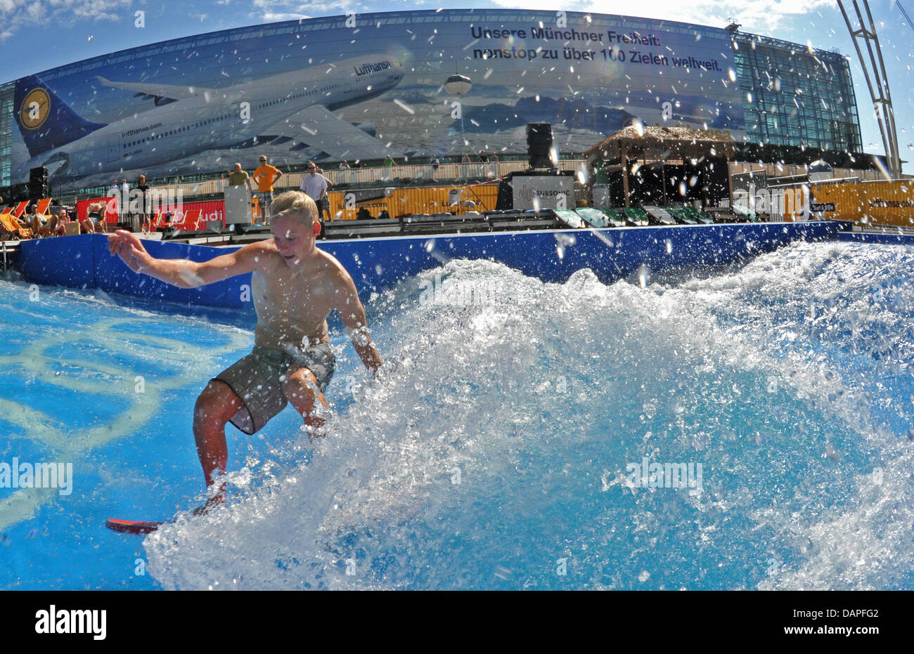 A man surfs on an artificial wave at an open area of the airport in Munich, Germany, 18 August 2011. The largest and only standing wave at an airport, acorrding to the organisers, can be visited and surfed until 28 August 2011. professionals and amateurs can show their skills at the nine metre wide and up to 1.5m high wave. Photo: Peter Kneffel Stock Photo