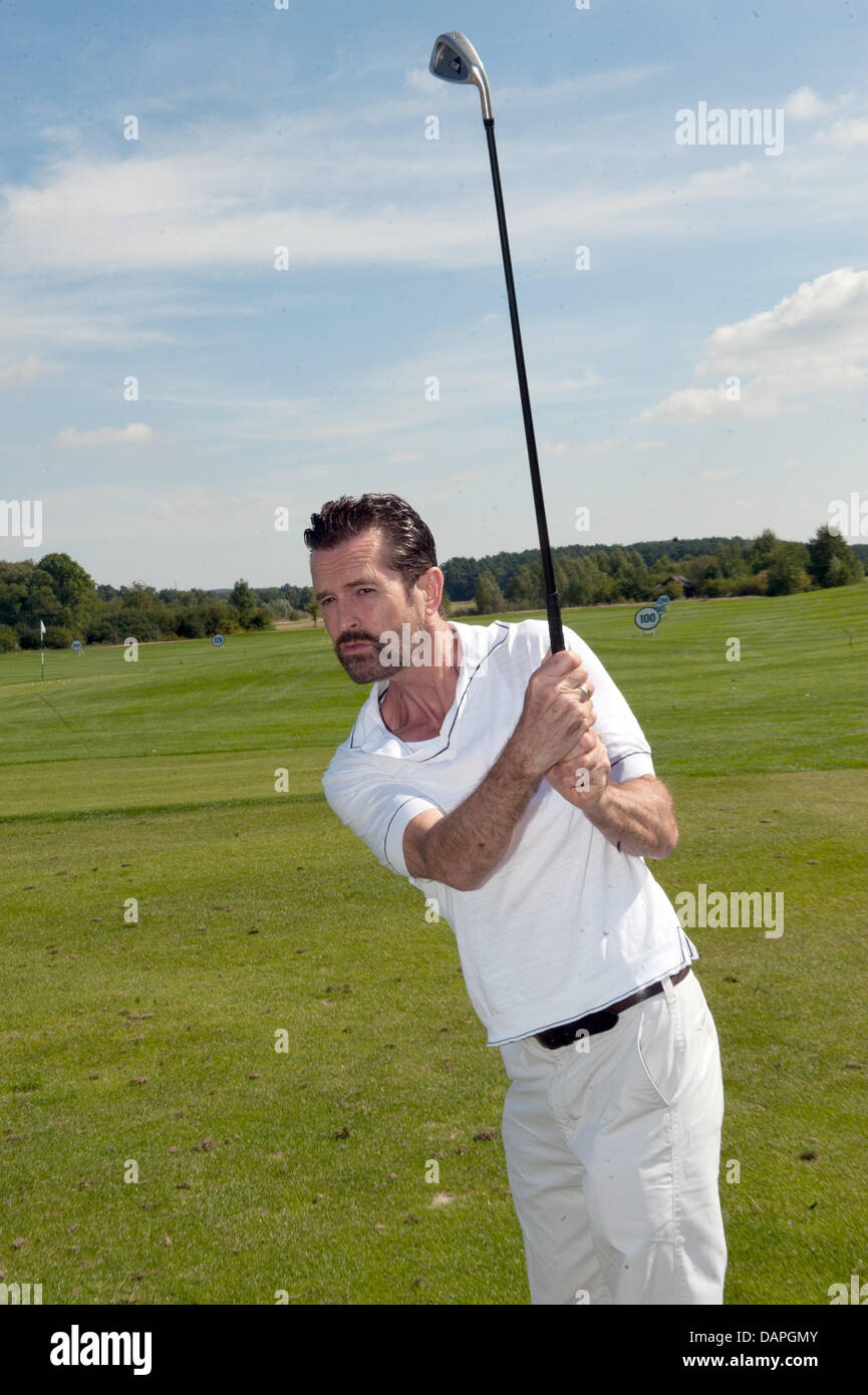 British actor Rupert Everett takes part in for trial golf lesson in the framework of the BMW Golf Cup 2011 at the Seddiner See golf and country club in Michendorf, Germany, 20 August 2011. A charity gala will take place in the evening for Achse e.V. (alliance for chronic and rare dieseases). Photo: Joerg Carstensen Stock Photo