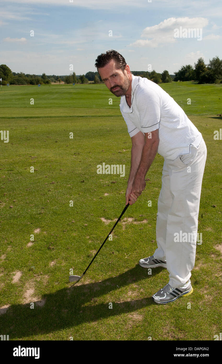 British actor Rupert Everett takes part in for trial golf lesson in the framework of the BMW Golf Cup 2011 at the Seddiner See golf and country club in Michendorf, Germany, 20 August 2011. A charity gala will take place in the evening for Achse e.V. (alliance for chronic and rare dieseases). Photo: Joerg Carstensen Stock Photo