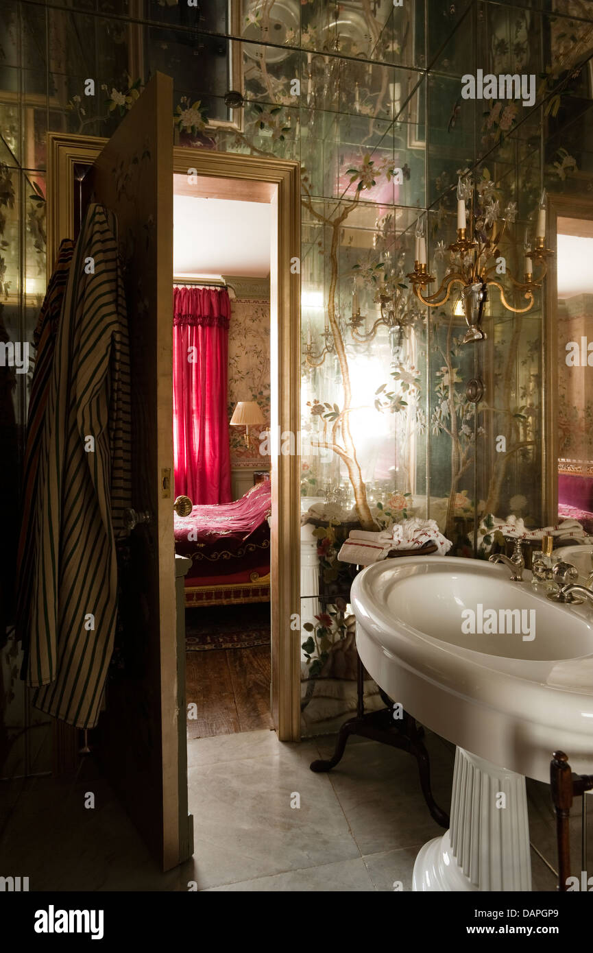 Bathroom with mirror-lined walls and ceiling and Bagues rock-crystal sconces. Stock Photo