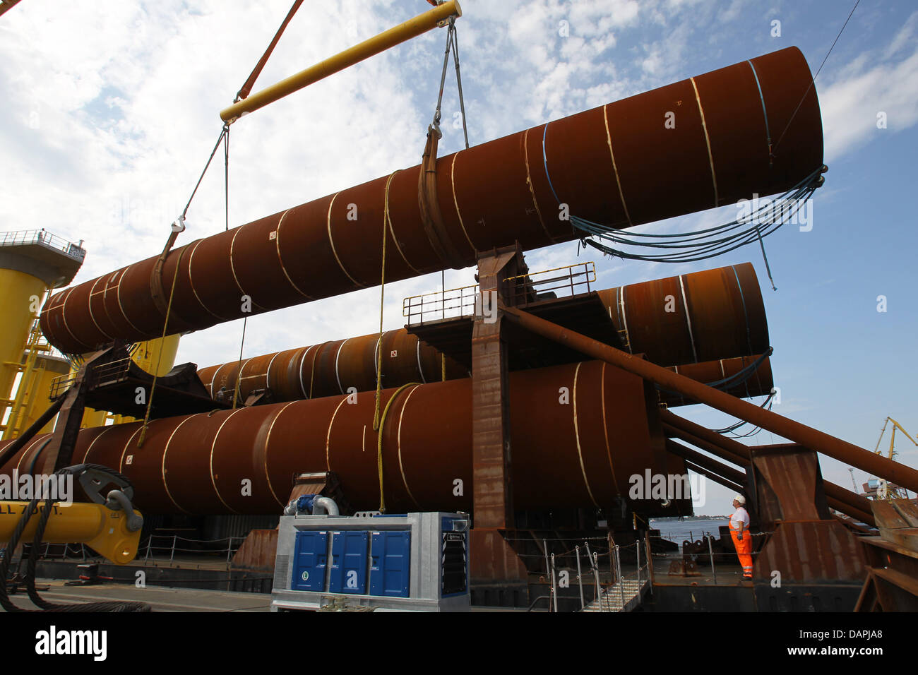 A 45 meter lon monopile with a weight of 260 tons and a diameter of 4.70 meters is loaded onto a barge for the offshore windfarm 'London Array' at the large-diameter pipe factory EEW Special Pipe Constructions at the sea port in Rostock, Germany, 23 August 2011. The Rostock company is delivering all 177 foundations for the world's largest windfarm on the coast of Great Britain. All Stock Photo