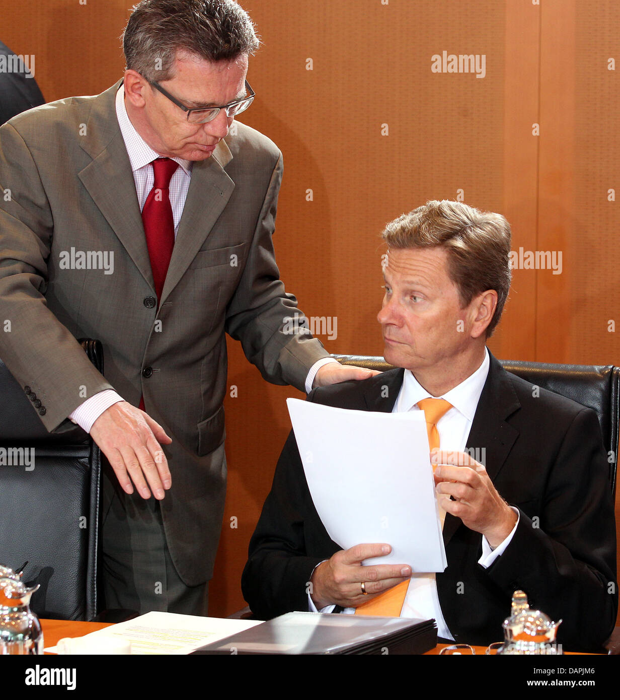 German Minister of Defense Thomas de Maiziere (L) and Foreign Minister Guido Westerwelle converse prior to a cabinet meeting at the Chancellery in Berlin, Germany, 24 August 2011. Among other issues, the cabinet will discuss internet security measures for electronic payment transactions. Photo: Wolfgang Kumm Stock Photo