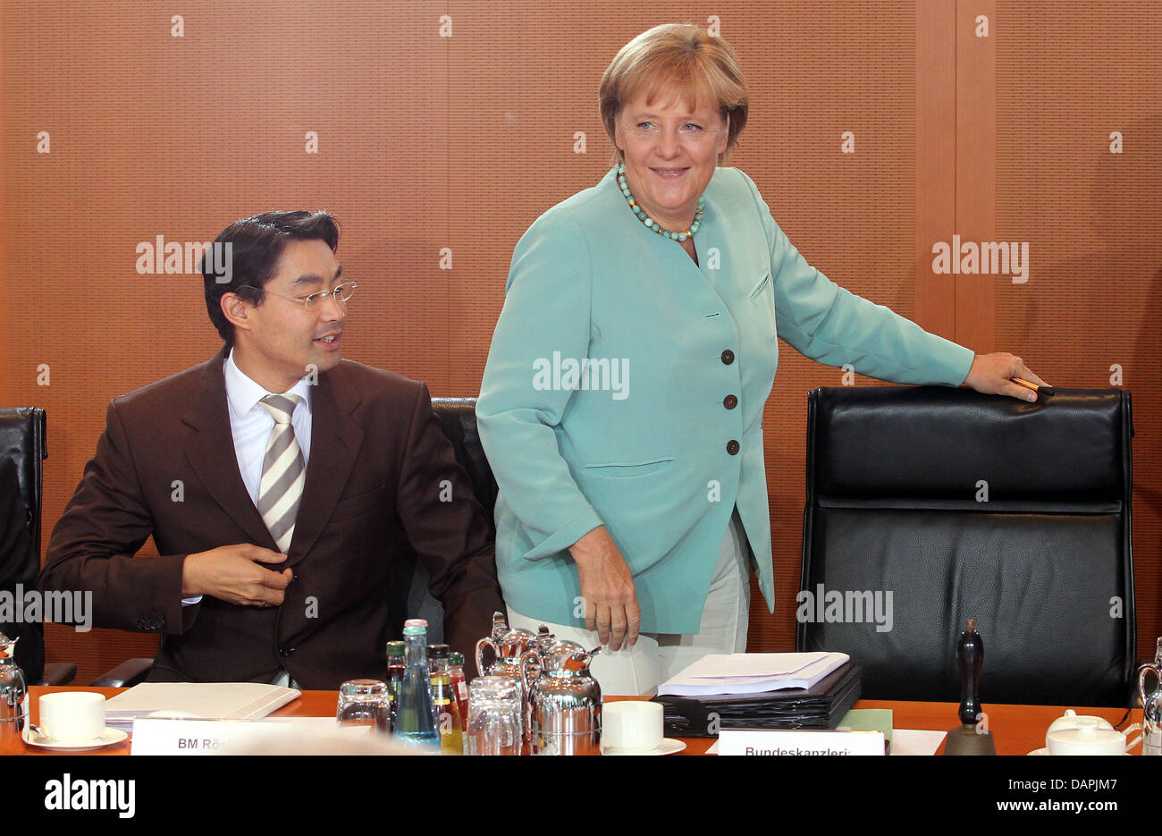 German Chancellor Angela Merkel (R) and Minister for Economics Philipp Roesler converse prior to a cabinet meeting at the Chancellery in Berlin, Germany, 24 August 2011. Among other issues, the cabinet will discuss internet security measures for electronic payment transactions. Photo: Wolfgang Kumm Stock Photo