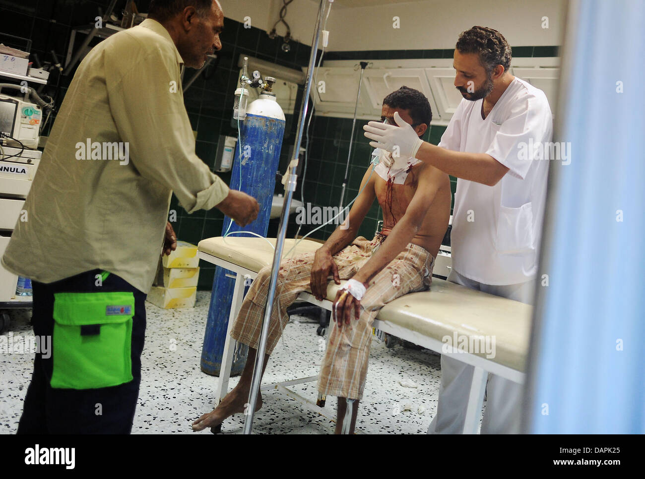 Ein schwer verwundeter Mann (M) sitzt am Mittwoch (24.08.2011) in einem Krankenhaus in al Sawija, Libyen, rund 50 Kilometer westlich der Hauptstadt Tripolis und wird behandelt. Das Regime des libyschen Diktators Gaddafi ist am Ende, doch trotz der Siegesfeiern der Rebellen kämpfen seine letzten Getreuen erbittert gegen den Untergang. In Tripolis und anderen Orten Libyens lieferten  Stock Photo