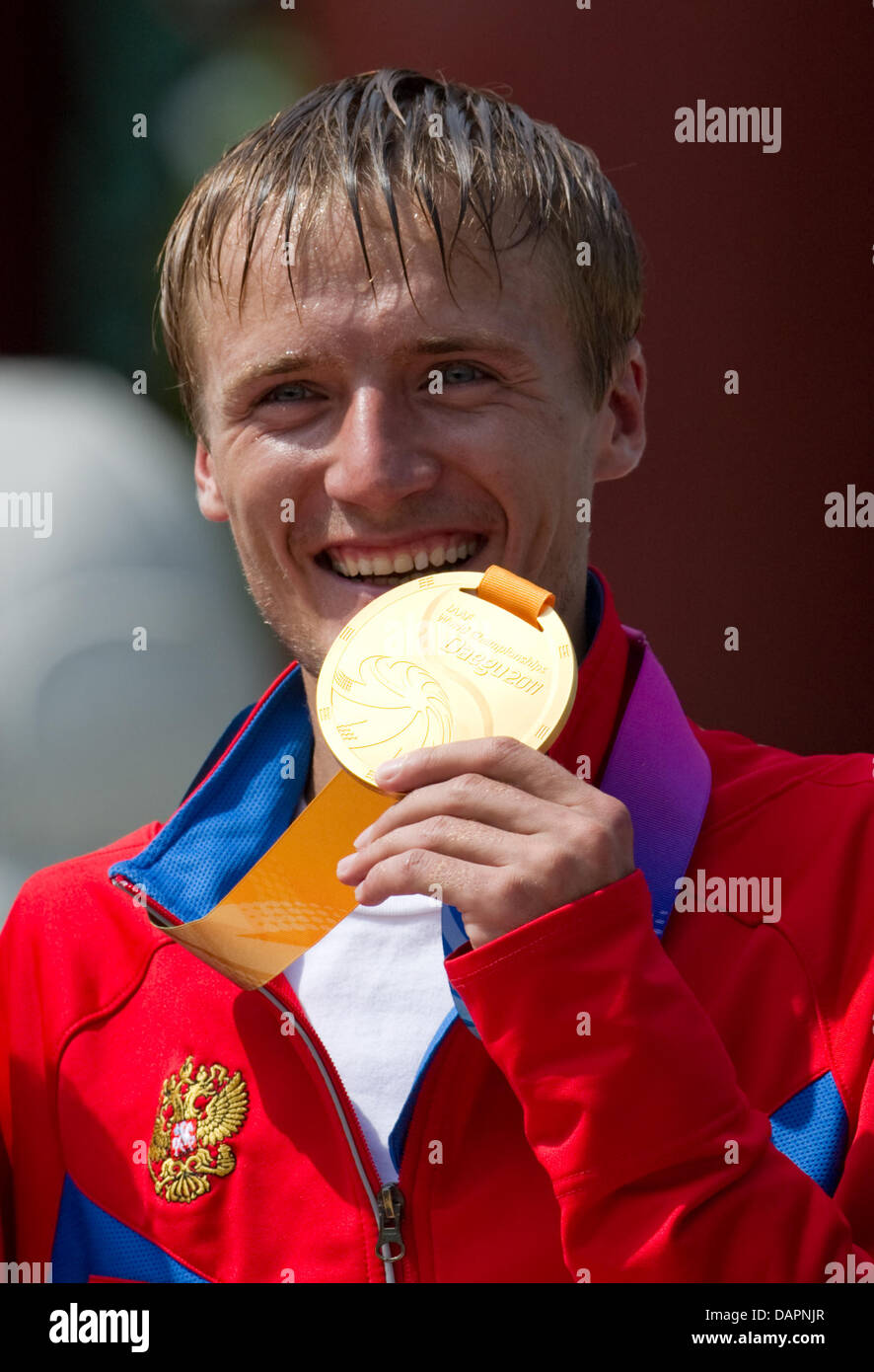 Winner Valeriy Borchin of Russia shows his gold medal for finishing first place in the Men 20 Kilometres Race Walk of the 13th IAAF World Championships in Daegu, Republic of Korea, 28 August 2011. Kanaykin ranked second. Photo: Bernd Thissen dpa Stock Photo