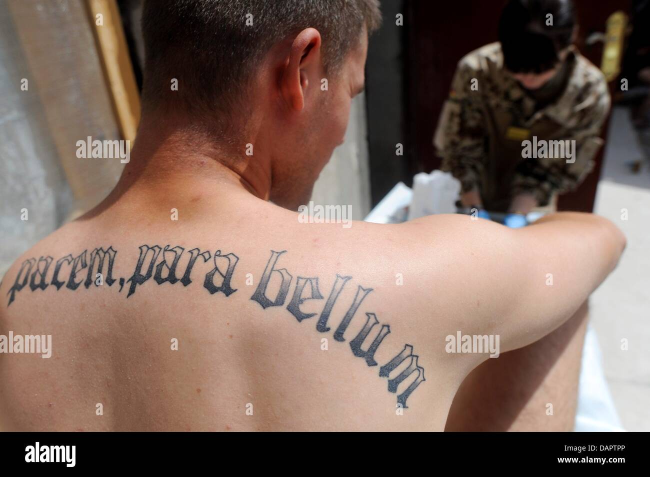 Si vis pacem, para bellum.' ('If you wish for peace, prepare for war') is  tattooed on the back of a German soldier, who is preparing for a mission in  the headquarters in