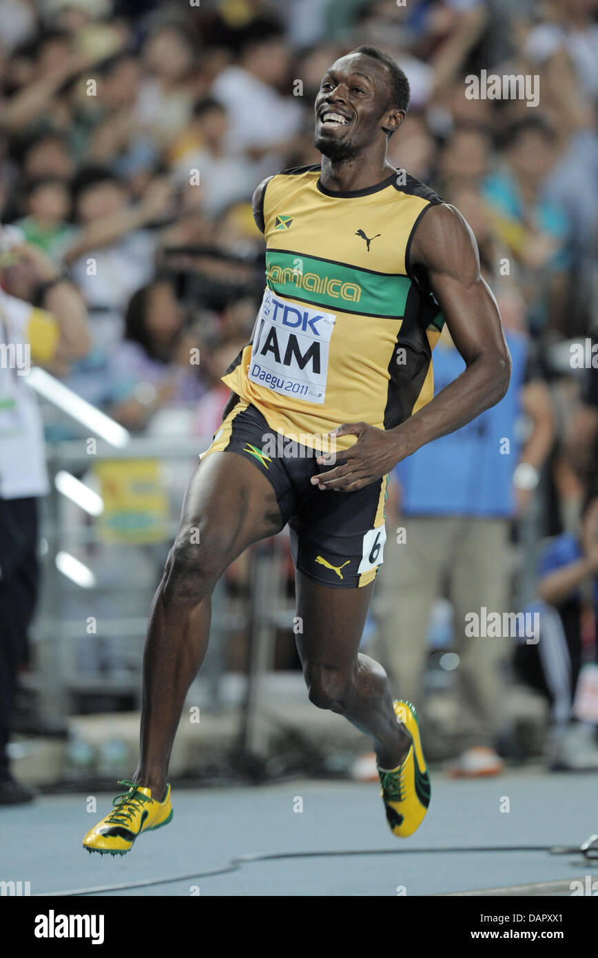 Usain Bolt from Jamaica reacts after crossing the finish line to win