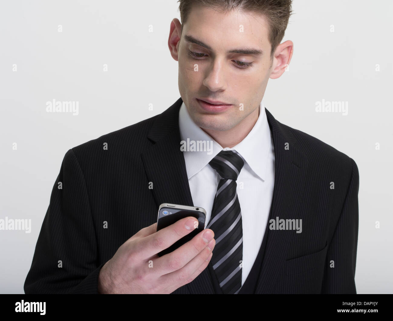 Businessman in suit and tie texting on his phone Stock Photo