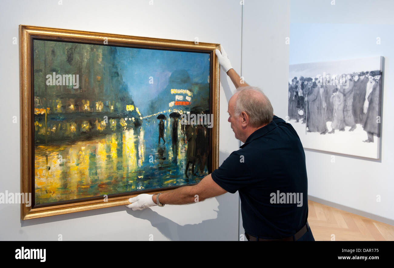 A Man Hangs The Painting Potsdamer Platz Bei Nacht Potsdamer Stock Photo Alamy