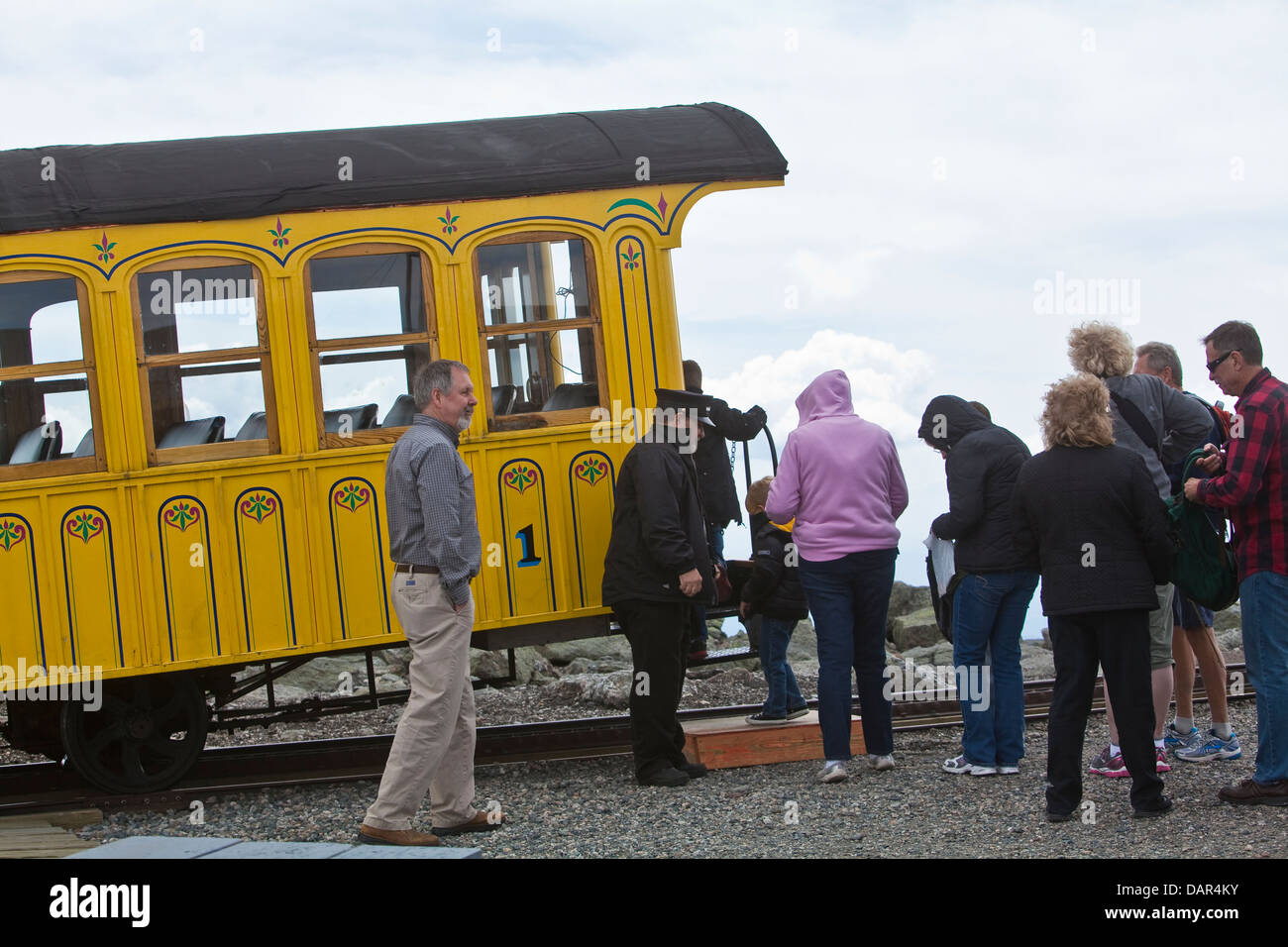 Tourists hop on the Cog Railway train at the Mount Washington summit in