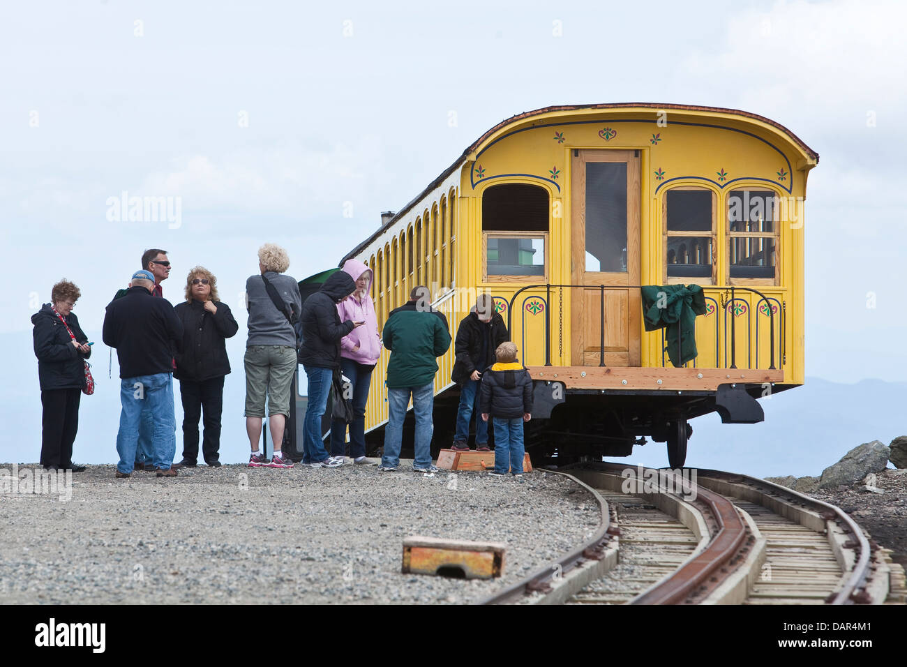 Tourists hop on the Cog Railway train at the Mount Washington summit in