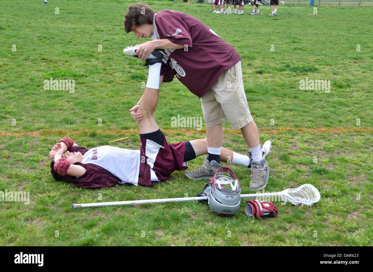 Lacrosse player helps his teammate with stretching before the game Stock Photo