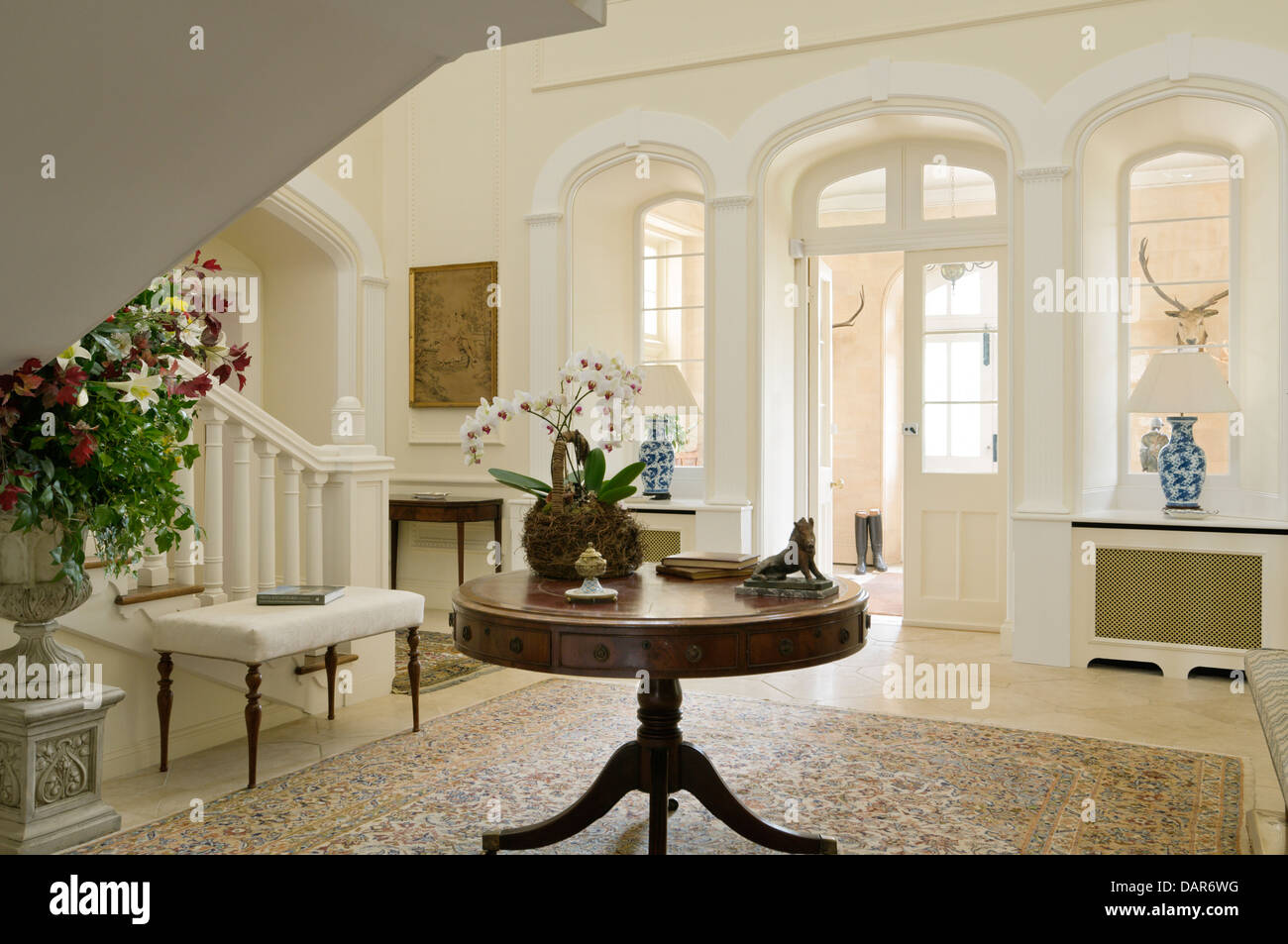 Antique round table in entrance hall of English country house Ampney Park, 17th century English manor Stock Photo